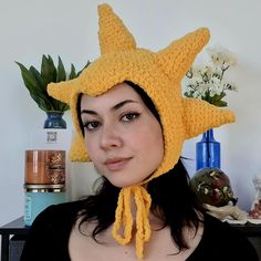 a woman wearing a yellow knitted star hat