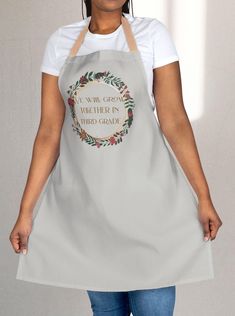 a woman wearing an apron that says, i will guess you're in third grade