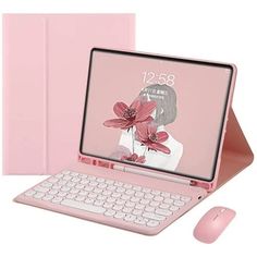 an open laptop computer sitting on top of a pink surface