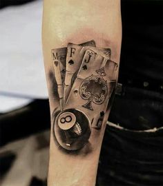 a man with a tattoo on his arm holding a pool ball and billiards