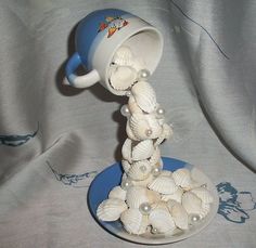 there is a blue and white coffee cup with seashells on the saucer