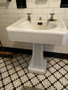 a white sink sitting on top of a black and white checkered floor