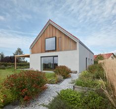 a house that is next to some flowers