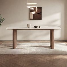 a white table sitting on top of a wooden floor next to a potted plant