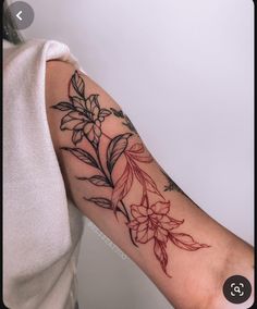 a woman's arm with flowers and leaves tattooed on the left side of her arm