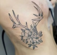 a woman's back with flowers and antlers on it