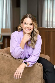 a woman sitting on top of a brown couch