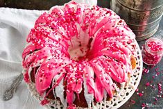 a bundt cake with pink sprinkles and white frosting on top