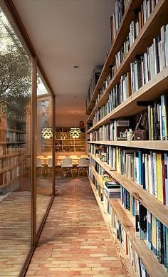 the bookshelves are full of books and there is a dining room in the background