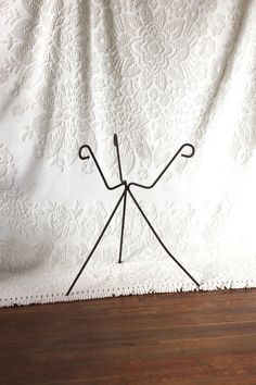 a black wire sculpture sitting on top of a wooden floor