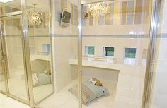 a bathroom with a glass shower stall and white tile flooring, along with a chandelier hanging from the ceiling