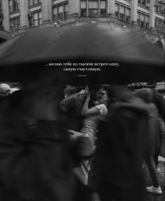 black and white photograph of people walking under an umbrella