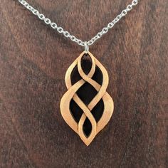 an intricate wooden pendant on a chain