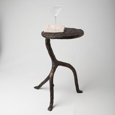 a small wooden table with a glass on it's top and a white towel on the end