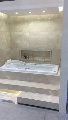 a large white bath tub sitting inside of a bathroom next to a wall mounted shower