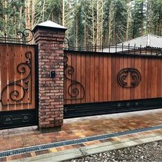 a brick fence with wrought iron gates