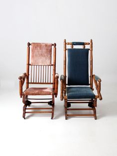 two wooden chairs sitting next to each other on a white surface with no one in it