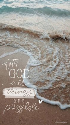 the words with god all things are possible written in white ink on an ocean beach