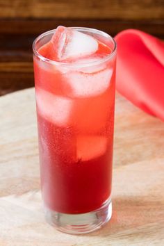 a red drink sitting on top of a wooden table