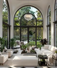 a living room filled with lots of furniture and large arched windows over the top of it