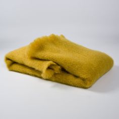 a yellow blanket laying on top of a white table