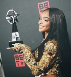 a woman holding an award in her right hand