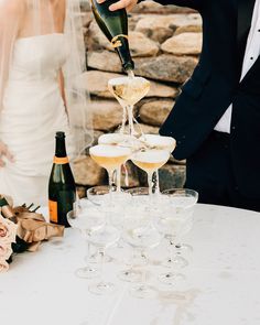 the bride and groom are pouring champagne into glasses