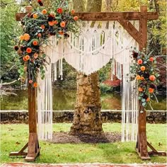 an outdoor wedding ceremony setup with flowers and macrame hanging from the tree, surrounded by greenery