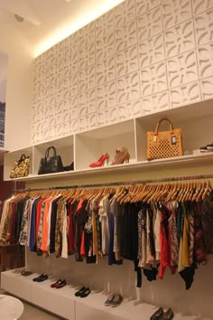 the closet is full of clothes and handbags on shelves with shoes hanging from them