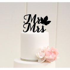 a white wedding cake with pink flowers and mr and mrs topper on the side