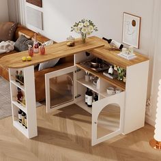 an open kitchen cabinet in the middle of a living room with wood floors and white walls