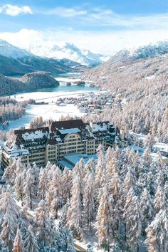 an aerial view of a resort surrounded by snow covered trees