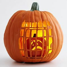 a lit pumpkin with a caged design on it