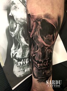 a man's arm with a black and grey skull tattoo on the left forearm