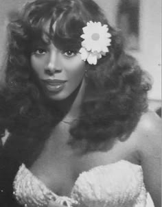 a black and white photo of a woman with a flower in her hair