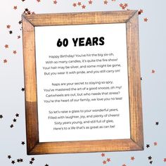 a wooden frame with the words 60 years written in black on it and stars around it