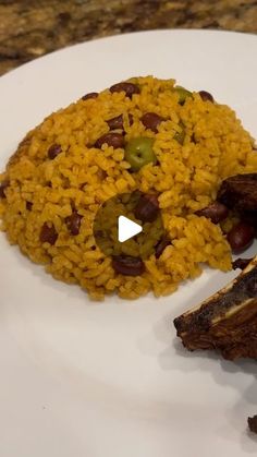 a white plate topped with meat and rice