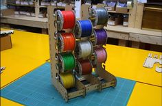 there are many spools of colorful thread on the stand in the shop for sale