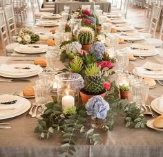 a long table is set with flowers and candles for an elegant dinner or reception party