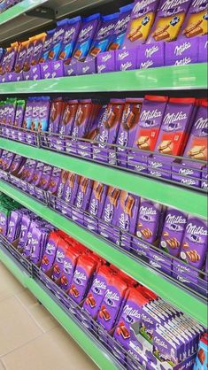 an aisle in a grocery store filled with lots of purple and orange food items on shelves