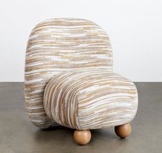 a chair made out of wood and fabric sitting on top of a cement floor next to a white wall