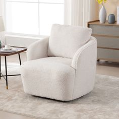 a white chair sitting on top of a rug in a living room