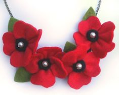 a necklace with red flowers and green leaves