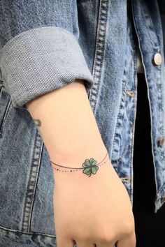 a woman's wrist with a four leaf clover tattoo on it