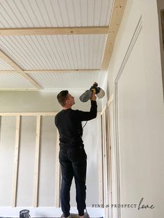 a man is painting the ceiling in his house