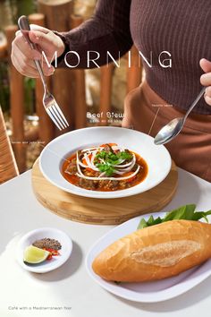 a woman is holding a fork and spoon over a bowl of food on a table