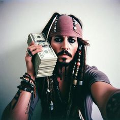 a man with dreadlocks holding money in front of his face