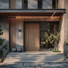 an entrance to a modern house with plants and trees in the foreground, on a sunny day