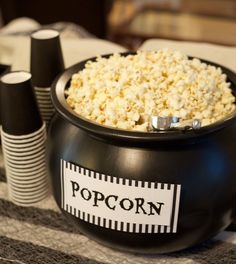 a black bowl filled with popcorn sitting on top of a table