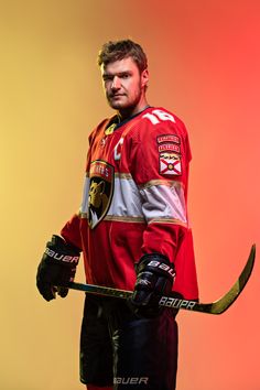 a man in red jersey holding a hockey stick